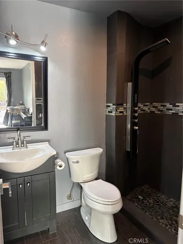 a bathroom with a sink a toilet a mirror and vanity
