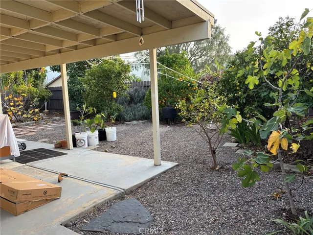 a view of a patio with table and chairs under an umbrella