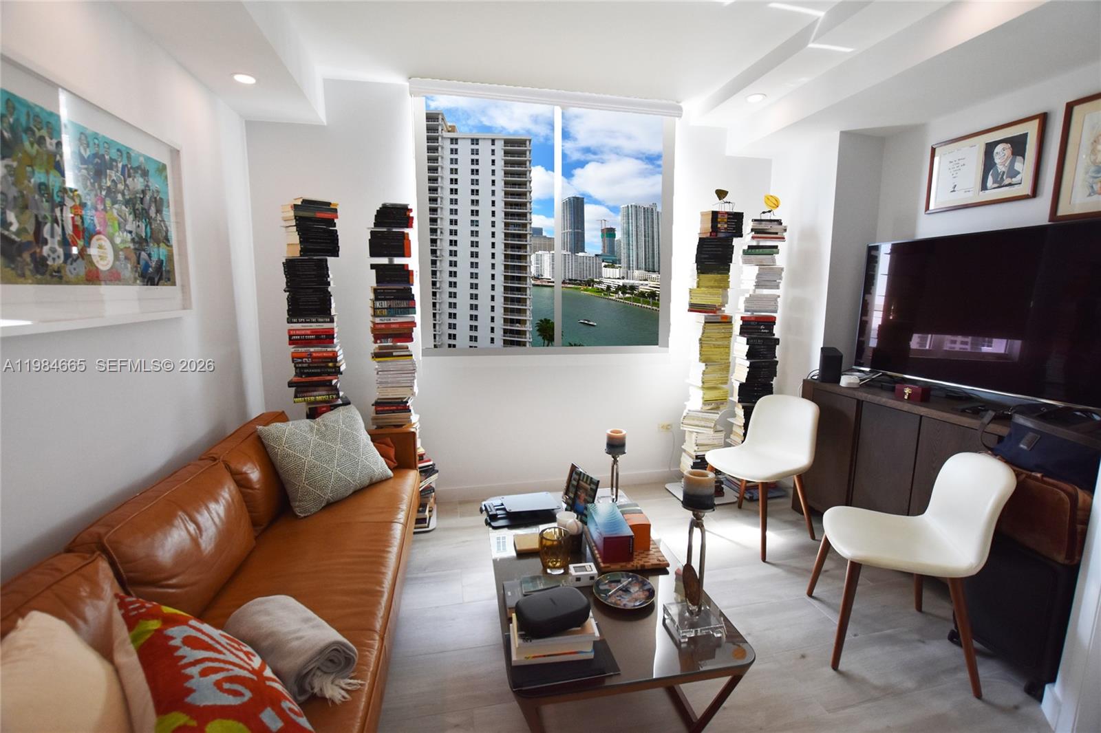 801 Brickell Key Boulevard, Unit 1209 Miami, FL 33131 - Photo 18 of 52 a living room with furniture a flat screen tv and a window
