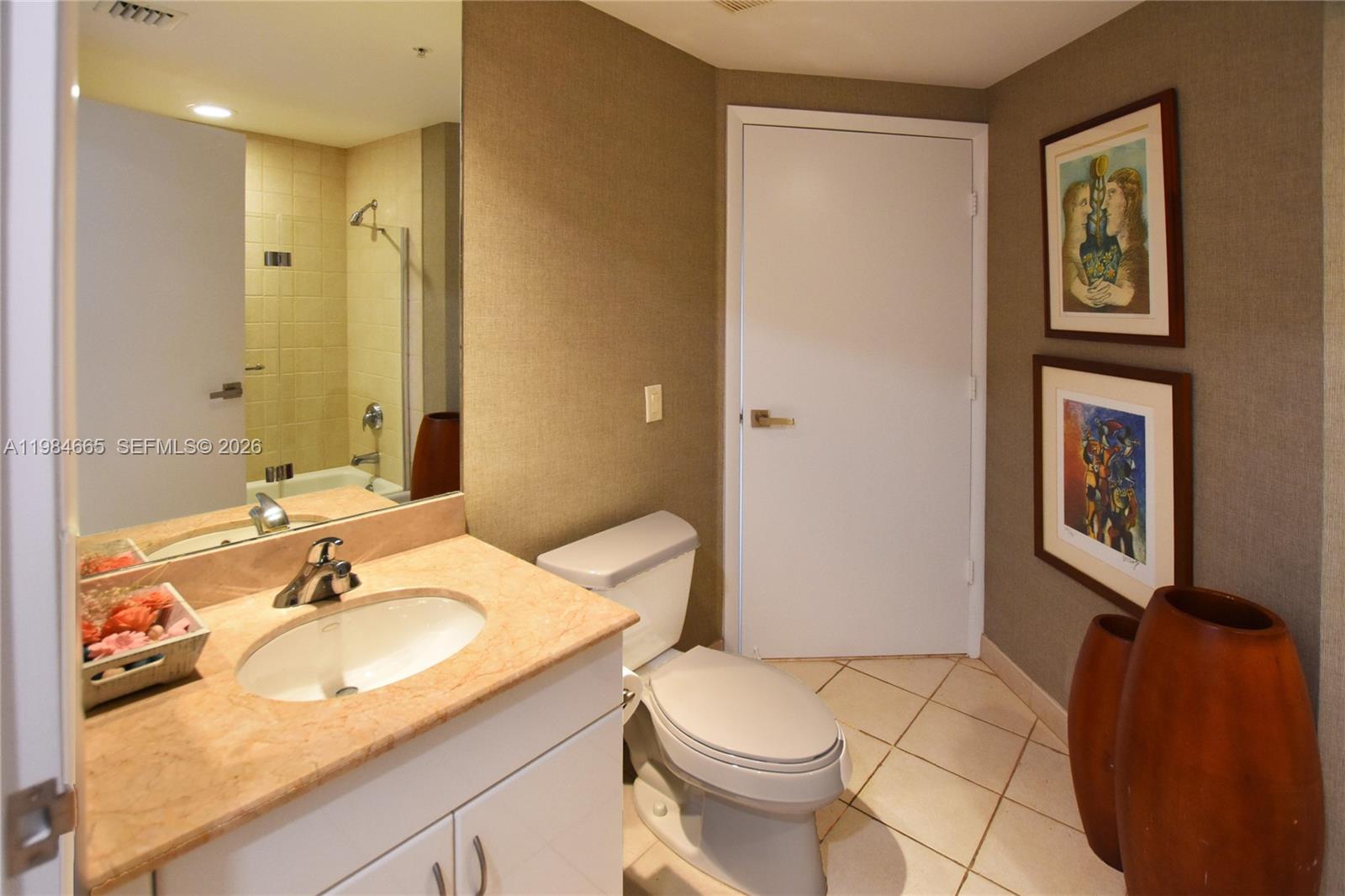 801 Brickell Key Boulevard, Unit 1209 Miami, FL 33131 - Photo 21 of 52 a bathroom with a granite countertop sink toilet and shower