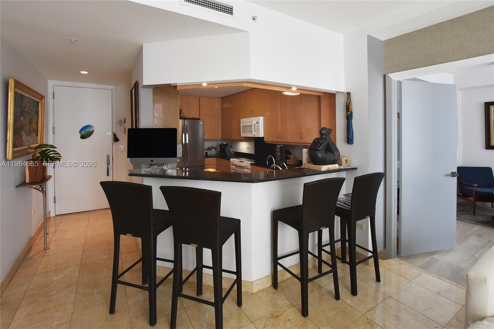 801 Brickell Key Boulevard, Unit 1209 Miami, FL 33131 - Photo 25 of 52 a kitchen with a dining table and chairs
