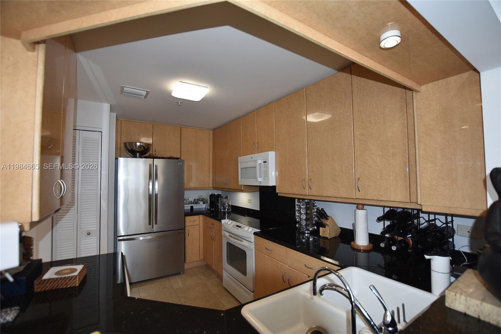 801 Brickell Key Boulevard, Unit 1209 Miami, FL 33131 - Photo 27 of 52 a kitchen with a refrigerator and a stove top oven