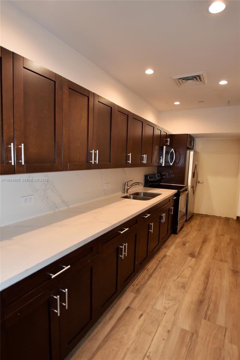 801 Brickell Key Boulevard, Unit 1209 Miami, FL 33131 - Photo 40 of 52 a kitchen with stainless steel appliances granite countertop a stove a sink and a microwave