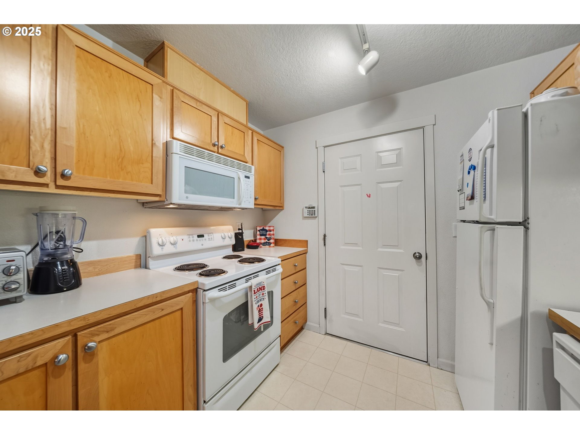 14615 Southwest Beard Road, Unit 101 Beaverton, OR 97007 - Photo 11 of 28 a kitchen with stainless steel appliances granite countertop a stove a sink and a refrigerator