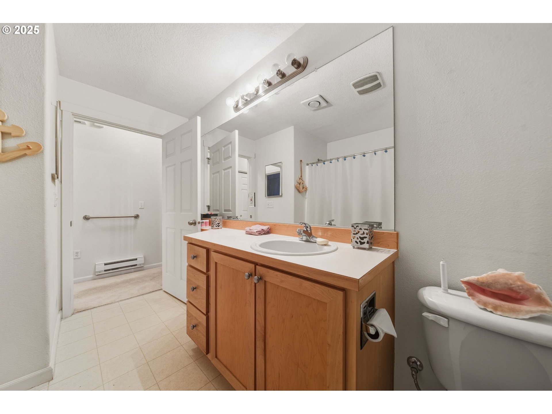 14615 Southwest Beard Road, Unit 101 Beaverton, OR 97007 - Photo 21 of 28 a bathroom with a sink a toilet a mirror and vanity