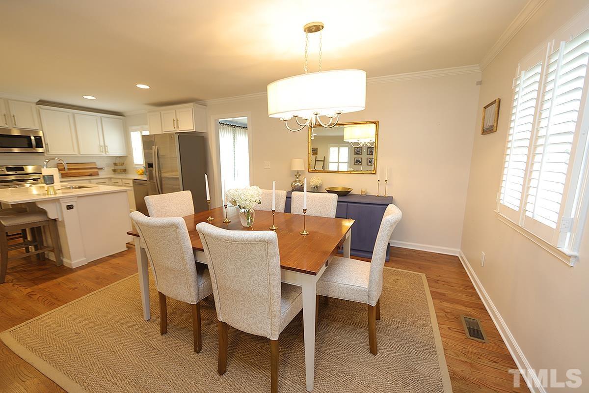 3404 Blue Ridge Road Raleigh, NC 27612 - Photo 14 of 36 a dining room with stainless steel appliances kitchen island granite countertop a dining table chairs and a refrigerator