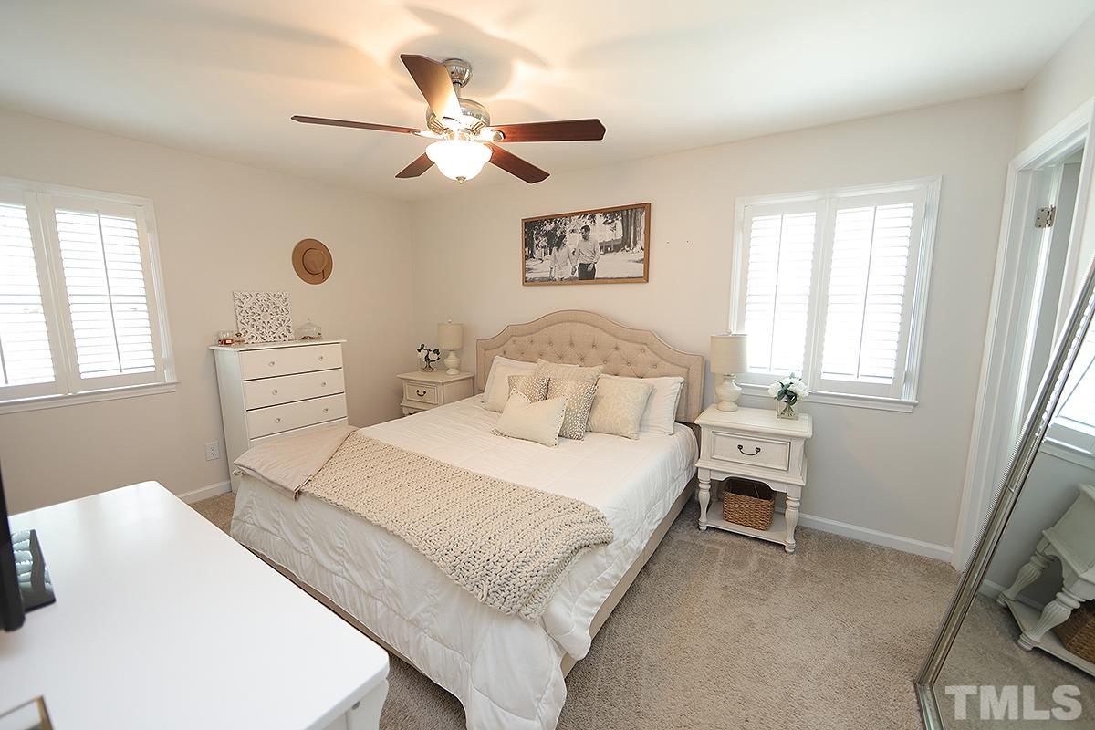 3404 Blue Ridge Road Raleigh, NC 27612 - Photo 24 of 36 a bedroom with a bed and a chandelier