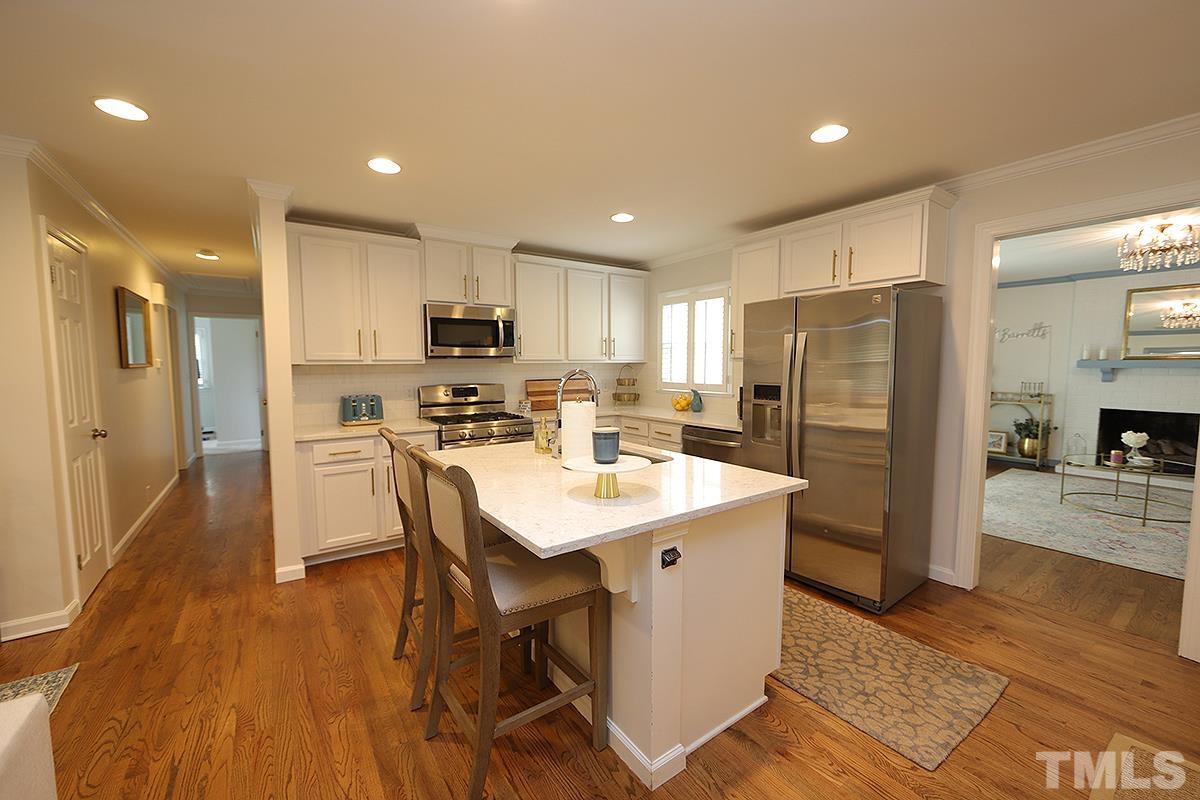 3404 Blue Ridge Road Raleigh, NC 27612 - Photo 9 of 36 a kitchen with stainless steel appliances a refrigerator a stove a sink dishwasher and a refrigerator with wooden floor