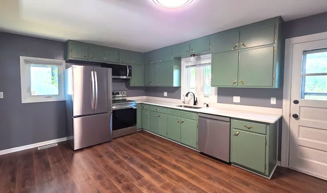 a kitchen with a refrigerator sink and cabinets