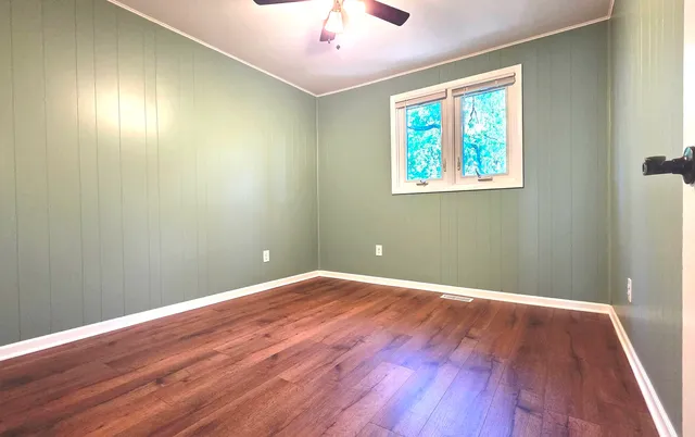 wooden floor in an empty room with a window