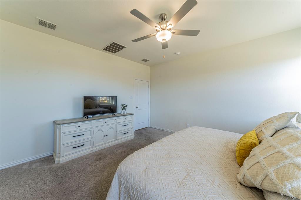 1240 Almond Road Azle, TX 76020 - Photo 11 of 26 a bedroom with a bed and a flat screen tv