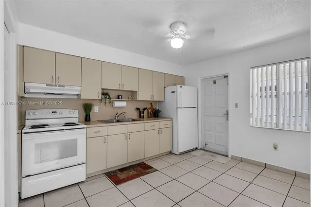 a kitchen with white cabinets and white appliances