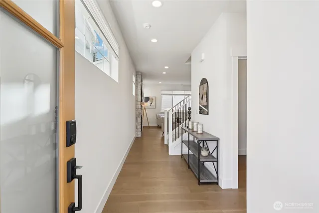 a living room with furniture and a dining table with wooden floor