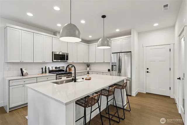 a kitchen with white cabinets and a stove top oven