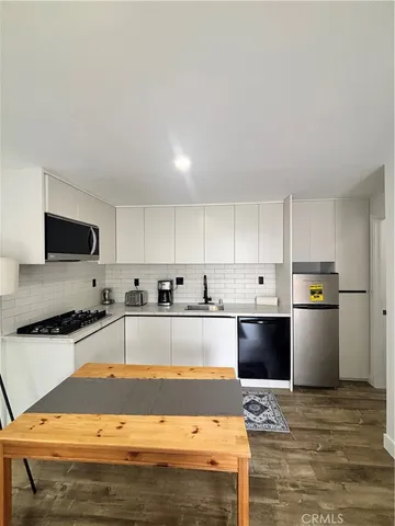 a large kitchen with kitchen island granite countertop a sink and white appliances