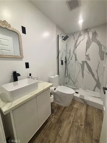 a view of a bathroom with a sink and mirror with toilet