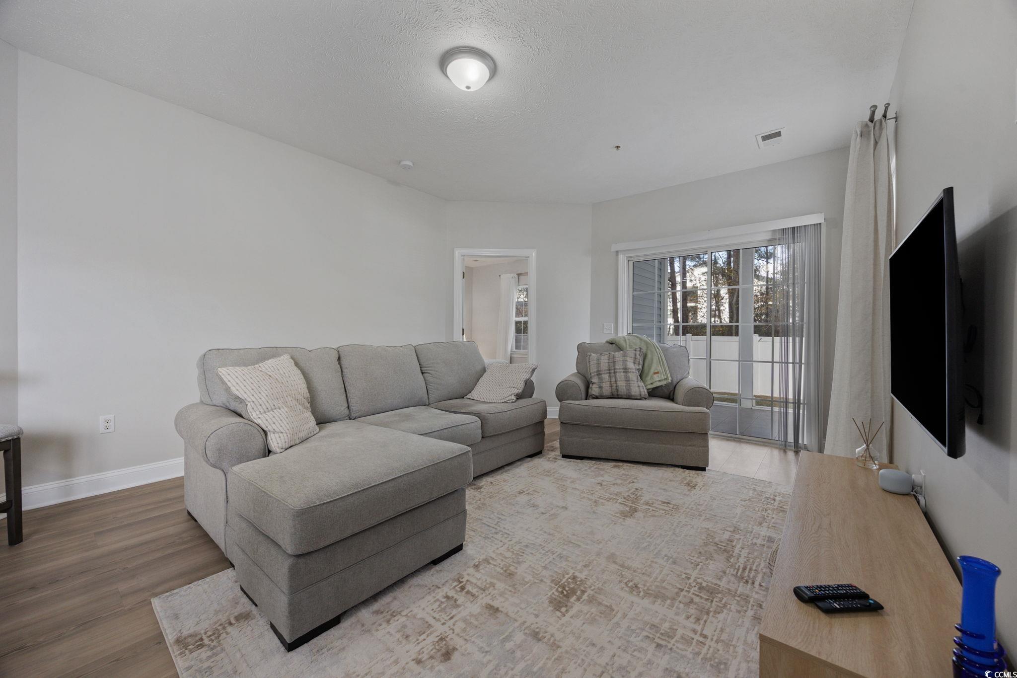 111 Fountain Pointe Lane, Unit 104 Myrtle Beach, SC 29579 - Photo 11 of 30 Living area featuring wood finished floors and baseboards