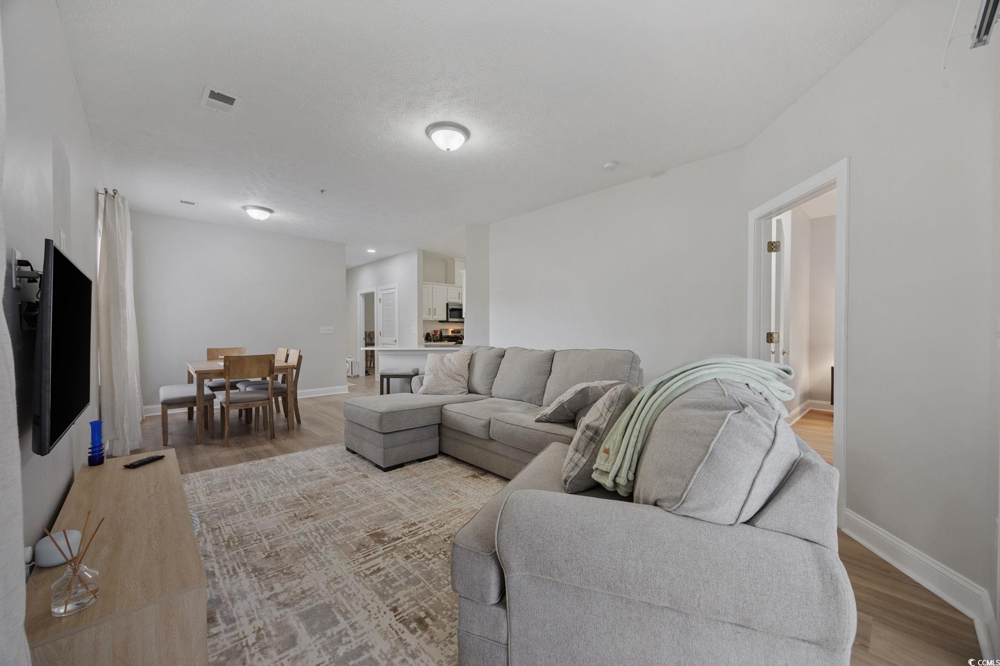 111 Fountain Pointe Lane, Unit 104 Myrtle Beach, SC 29579 - Photo 12 of 30 Living room with light wood finished floors and baseboards