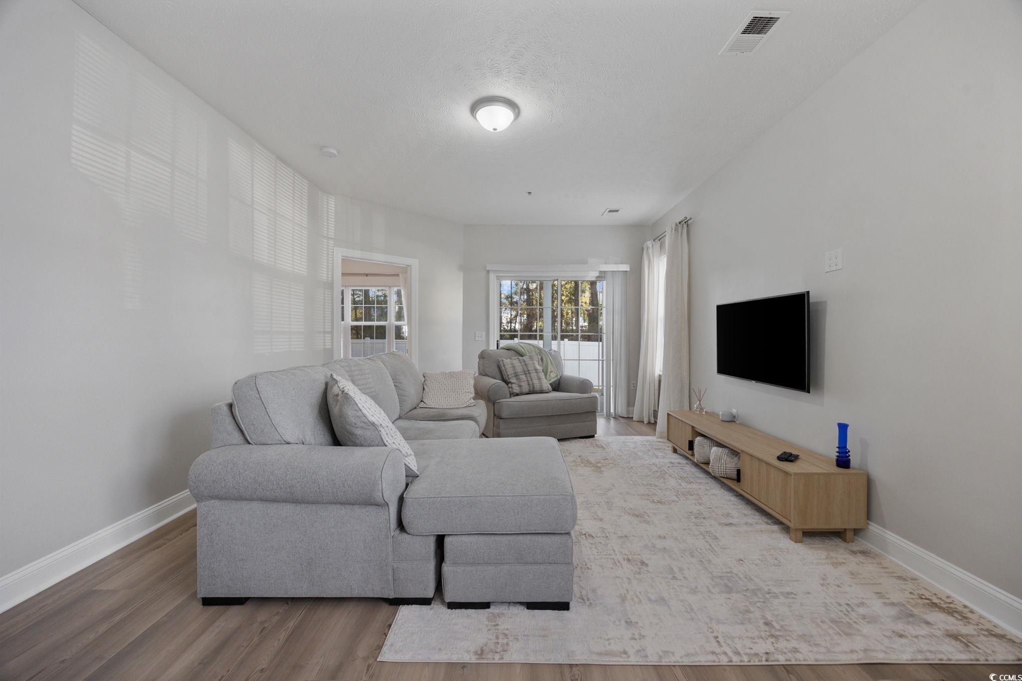 111 Fountain Pointe Lane, Unit 104 Myrtle Beach, SC 29579 - Photo 13 of 30 Living room with wood finished floors and baseboards