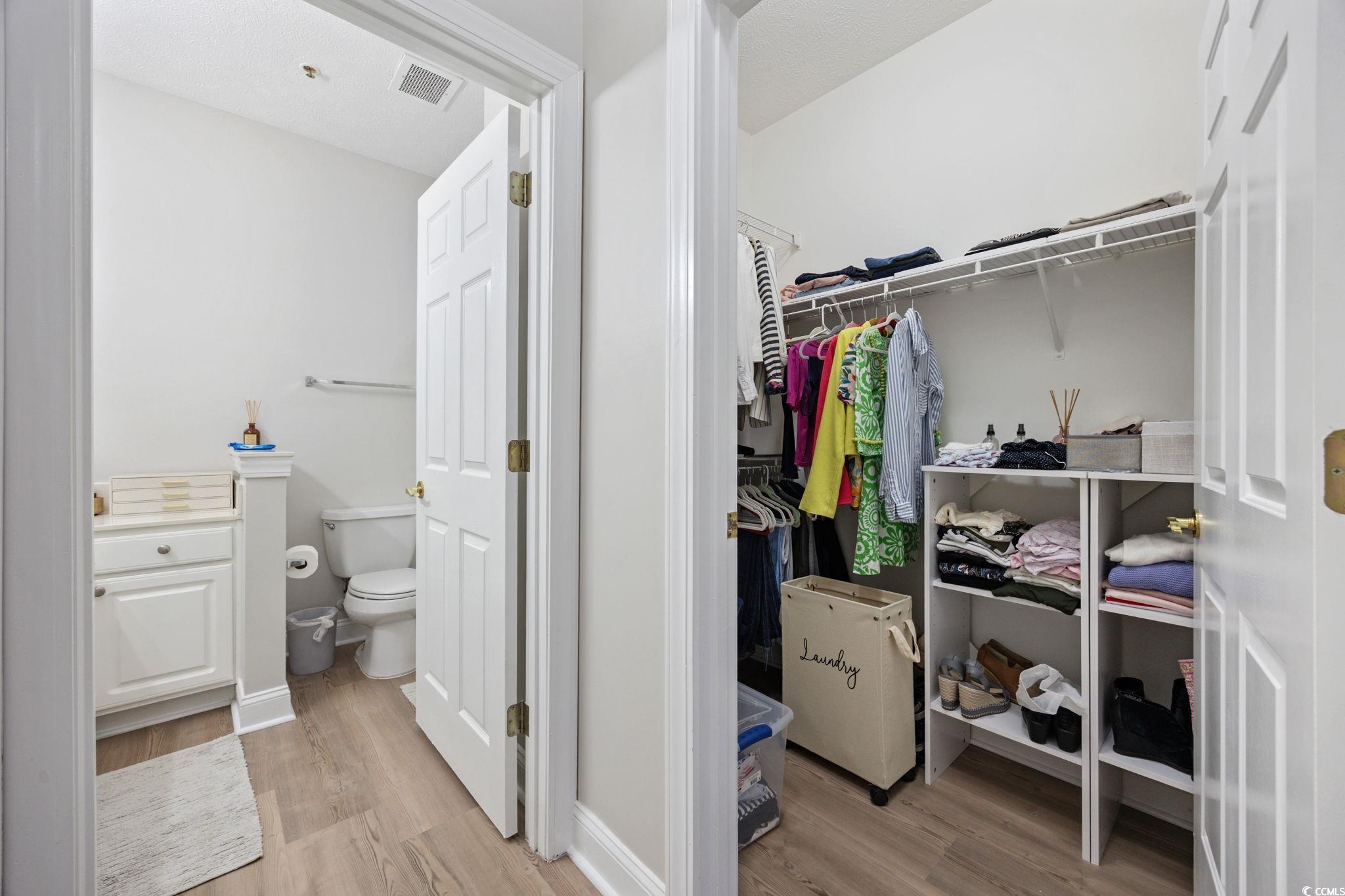 111 Fountain Pointe Lane, Unit 104 Myrtle Beach, SC 29579 - Photo 16 of 30 Bathroom featuring light wood-type flooring, a walk in closet, and vanity