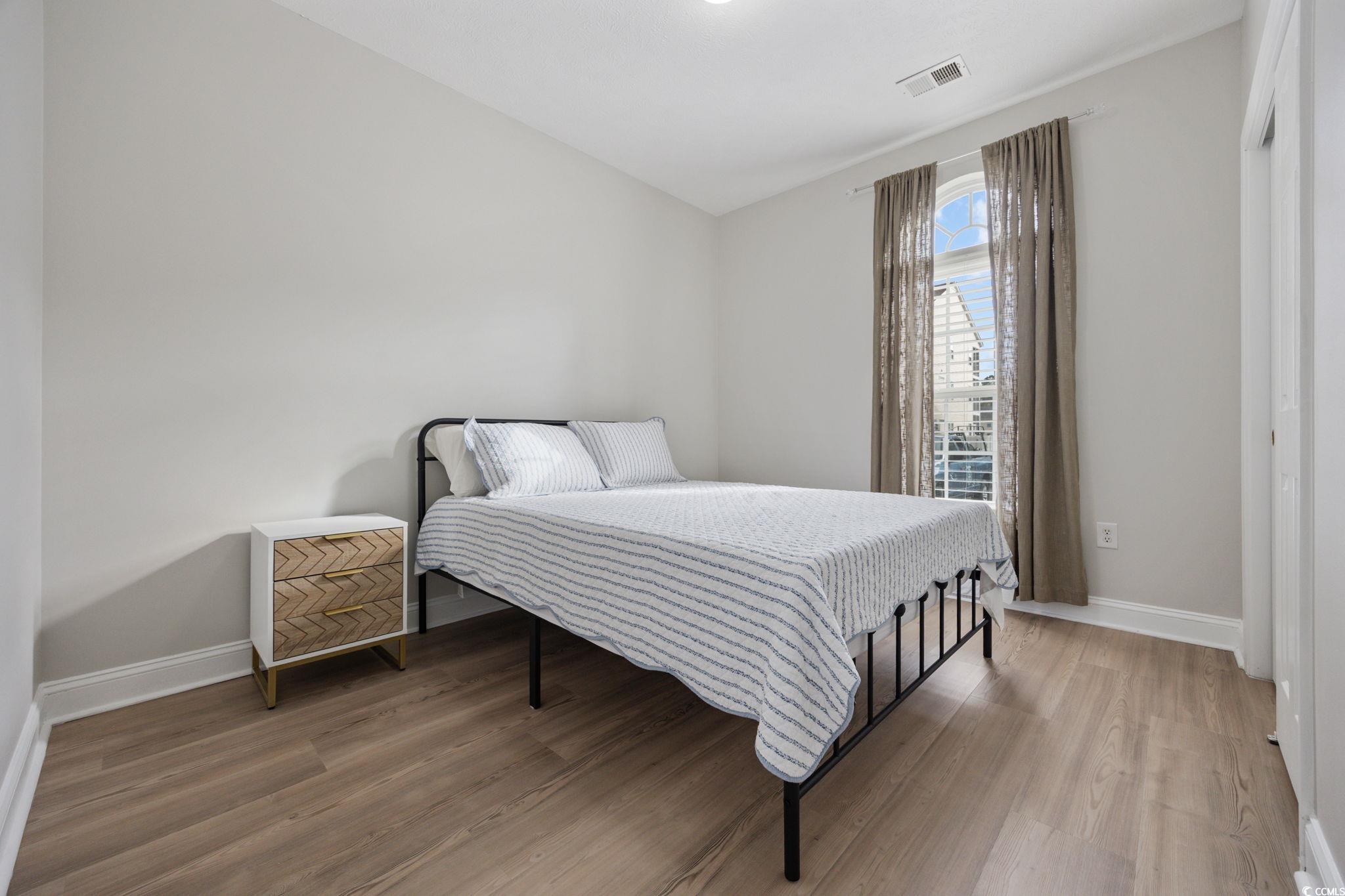 111 Fountain Pointe Lane, Unit 104 Myrtle Beach, SC 29579 - Photo 18 of 30 Bedroom with wood finished floors and baseboards