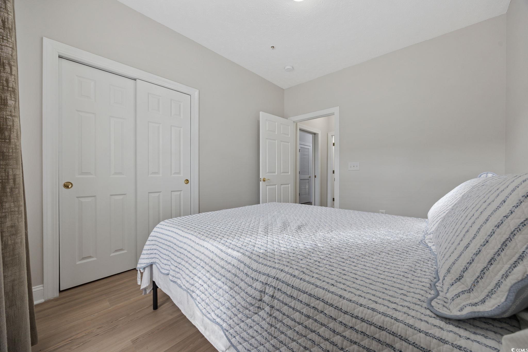 111 Fountain Pointe Lane, Unit 104 Myrtle Beach, SC 29579 - Photo 19 of 30 Bedroom featuring light wood-style flooring and a closet