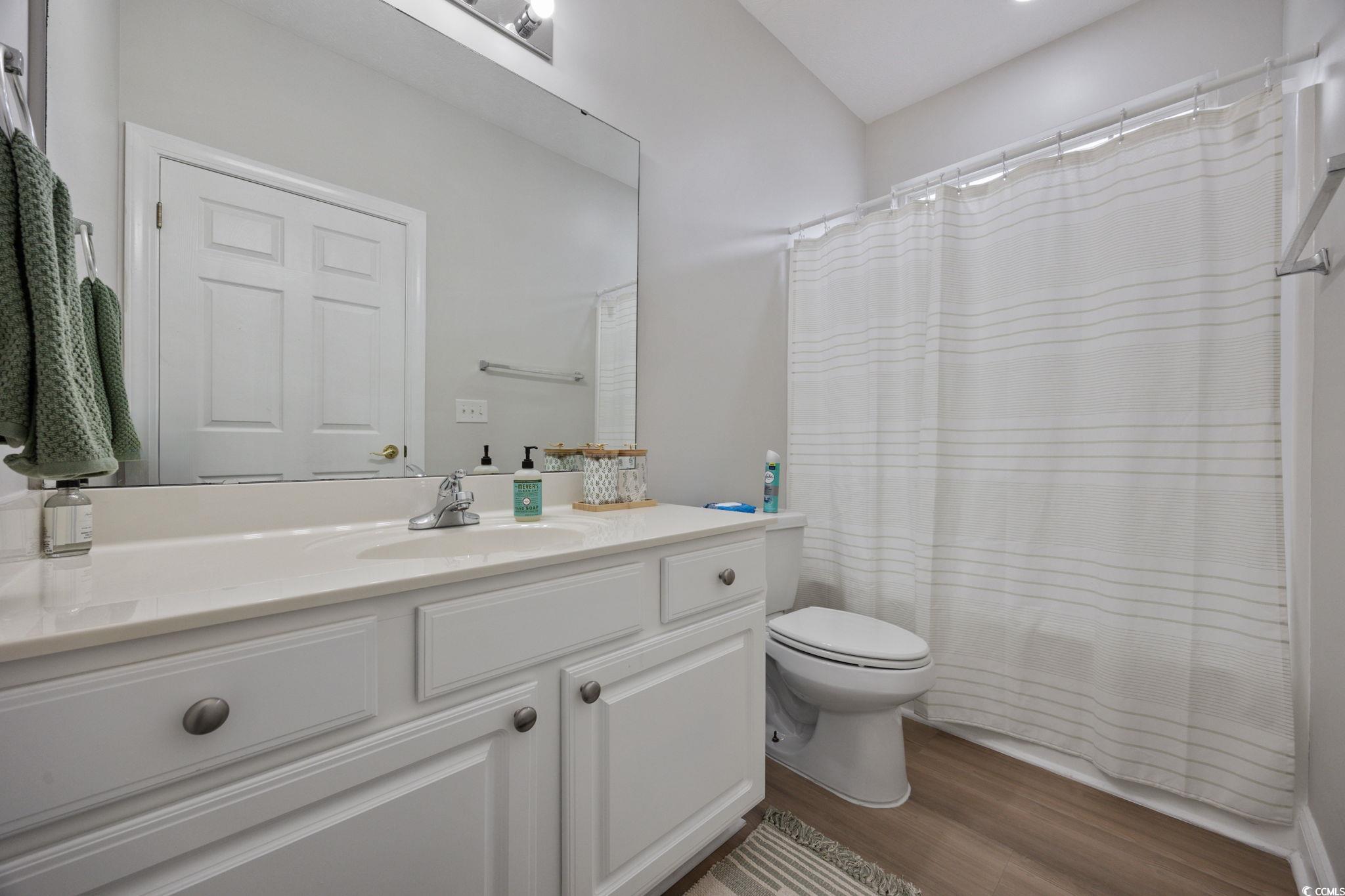 111 Fountain Pointe Lane, Unit 104 Myrtle Beach, SC 29579 - Photo 20 of 30 Bathroom with a shower with shower curtain, vanity, and dark wood-style floors