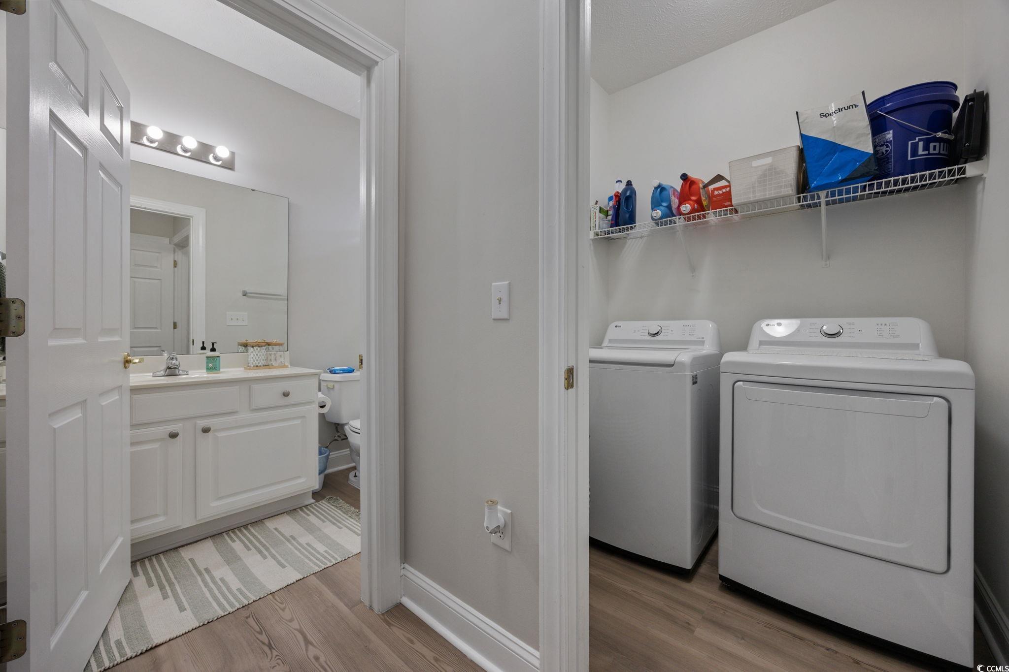 111 Fountain Pointe Lane, Unit 104 Myrtle Beach, SC 29579 - Photo 23 of 30 Washroom with light wood-style flooring and washing machine and dryer