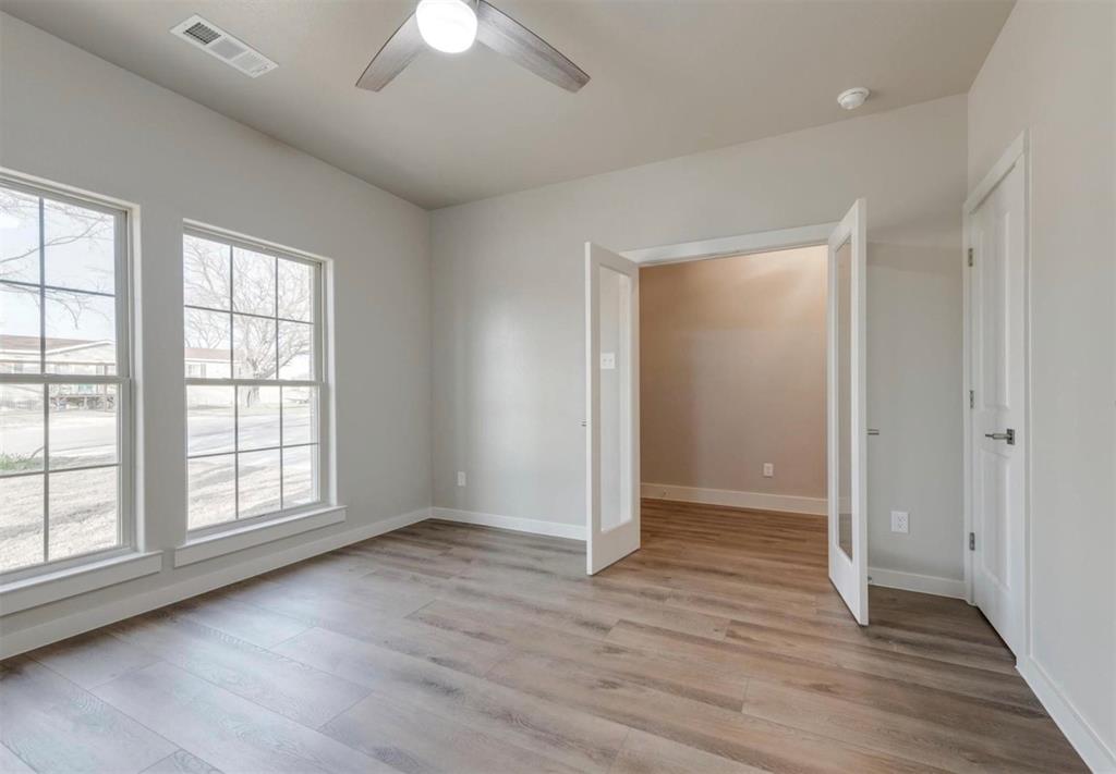 100 Hackberry Lane Roanoke, TX 76262 - Photo 2 of 10 an empty room with wooden floor chandelier and windows