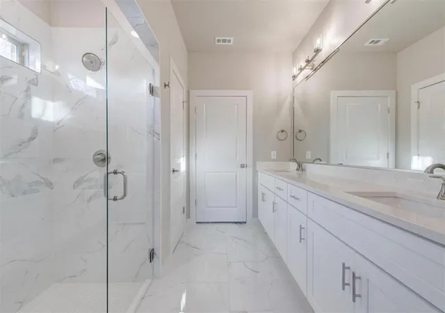 a spacious bathroom with a granite countertop sink mirror and shower