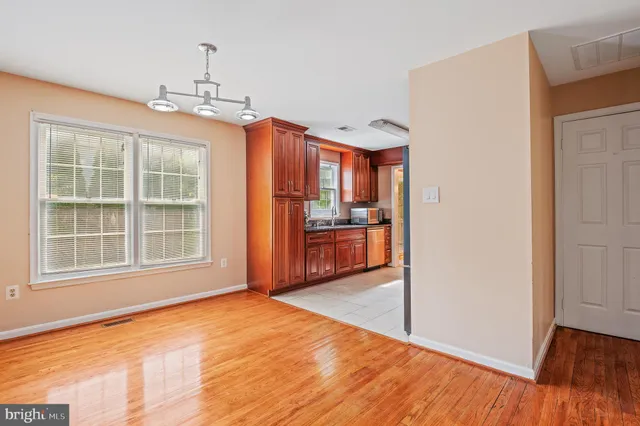 a view of an empty room with window and wooden floor