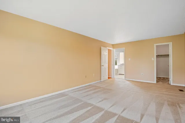 a view of an empty room with window and chandelier fan