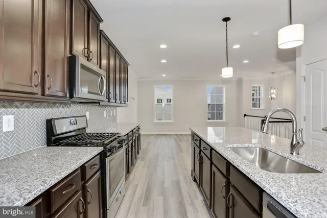 a kitchen with granite countertop kitchen island a sink a counter space appliances and cabinets
