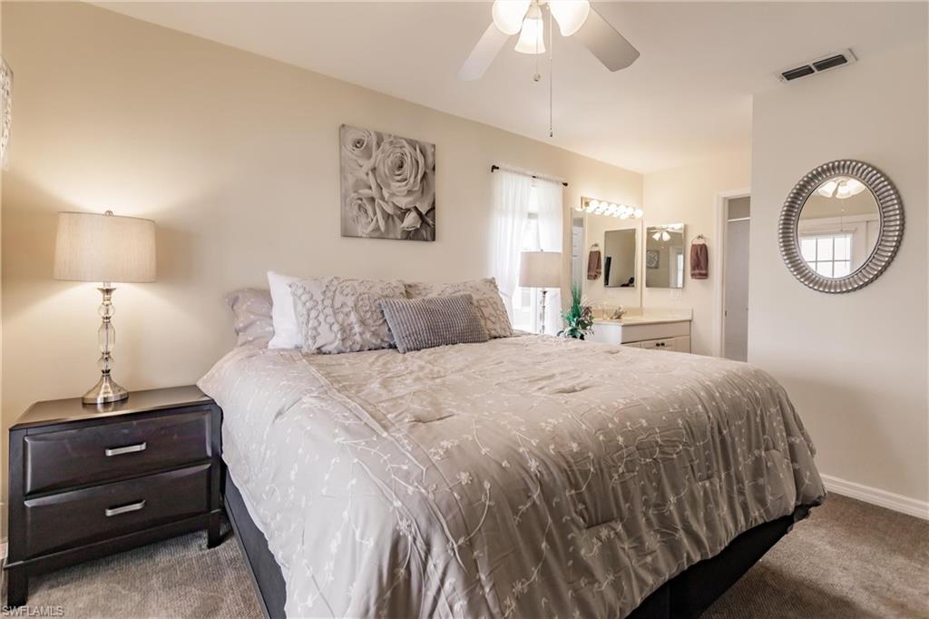 1315 Mainsail Drive, Unit 1115 Naples, FL 34114 - Photo 11 of 25 a bedroom with a bed and a lamp