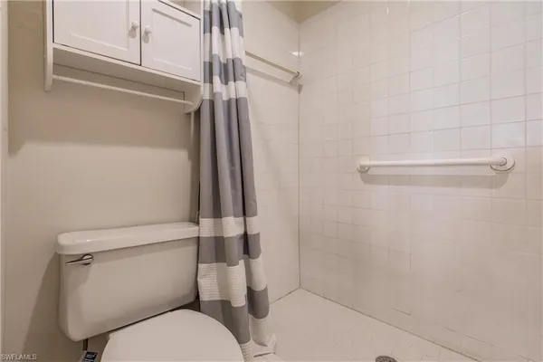 a white toilet sitting next to a shower