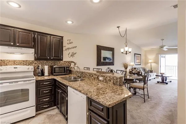 a kitchen with microwave a stove and chairs