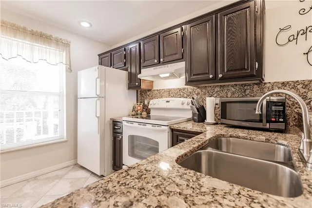 a kitchen with a sink cabinets and refrigerator