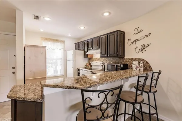 a kitchen with stainless steel appliances granite countertop a stove a sink and a refrigerator