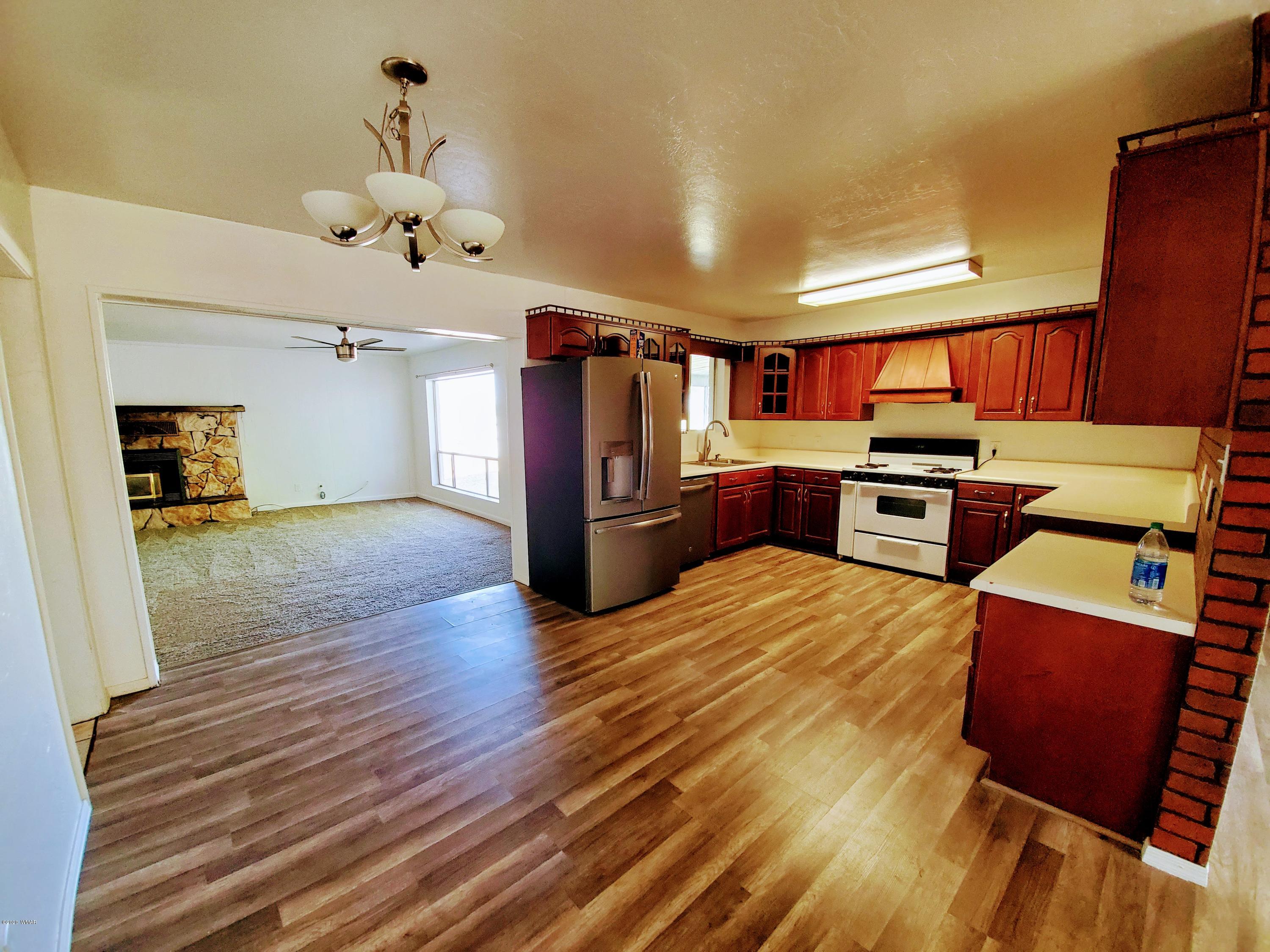 300 South 8th Street Snowflake, AZ 85937 - Photo 3 of 18 a open kitchen with stainless steel appliances kitchen island granite countertop a refrigerator stove oven and wooden floors