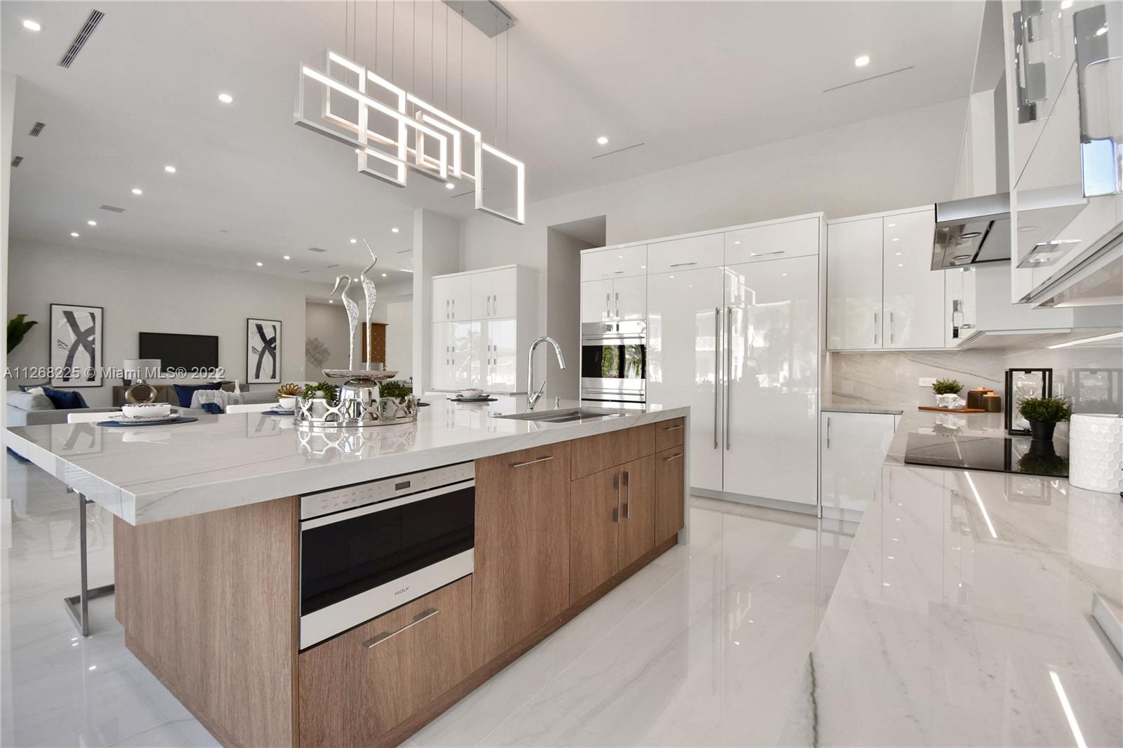 805 Northeast 70th Street Boca Raton, FL 33487 - Photo 12 of 63 a kitchen with stainless steel appliances kitchen island granite countertop a sink and a refrigerator