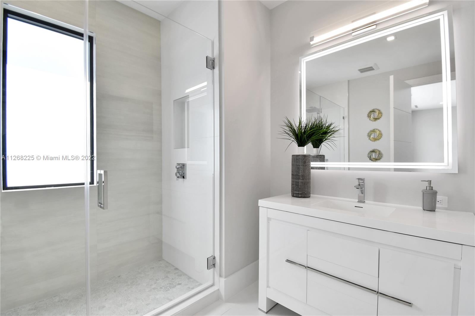 805 Northeast 70th Street Boca Raton, FL 33487 - Photo 26 of 63 a bathroom with a sink and a mirror