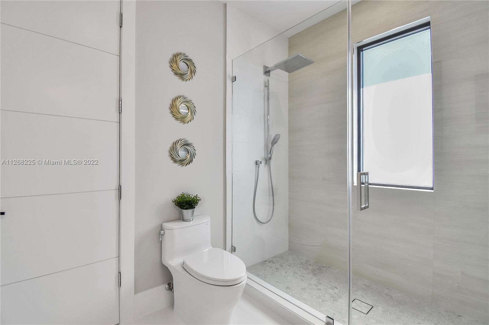 805 Northeast 70th Street Boca Raton, FL 33487 - Photo 27 of 63 a bathroom with a shower a toilet and a shower