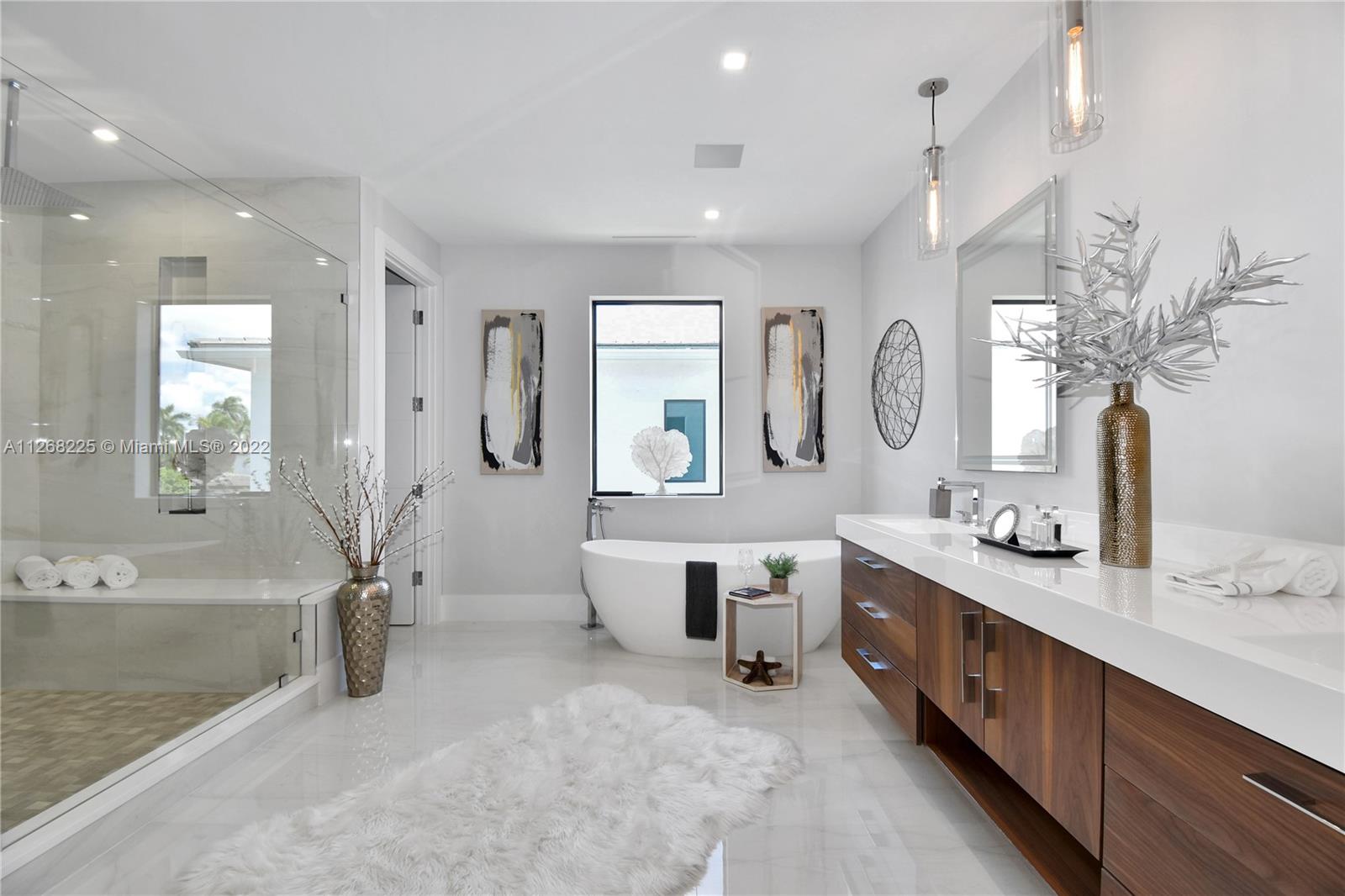 805 Northeast 70th Street Boca Raton, FL 33487 - Photo 34 of 63 a spacious bathroom with double vanity sinks a large mirror and a bathtub