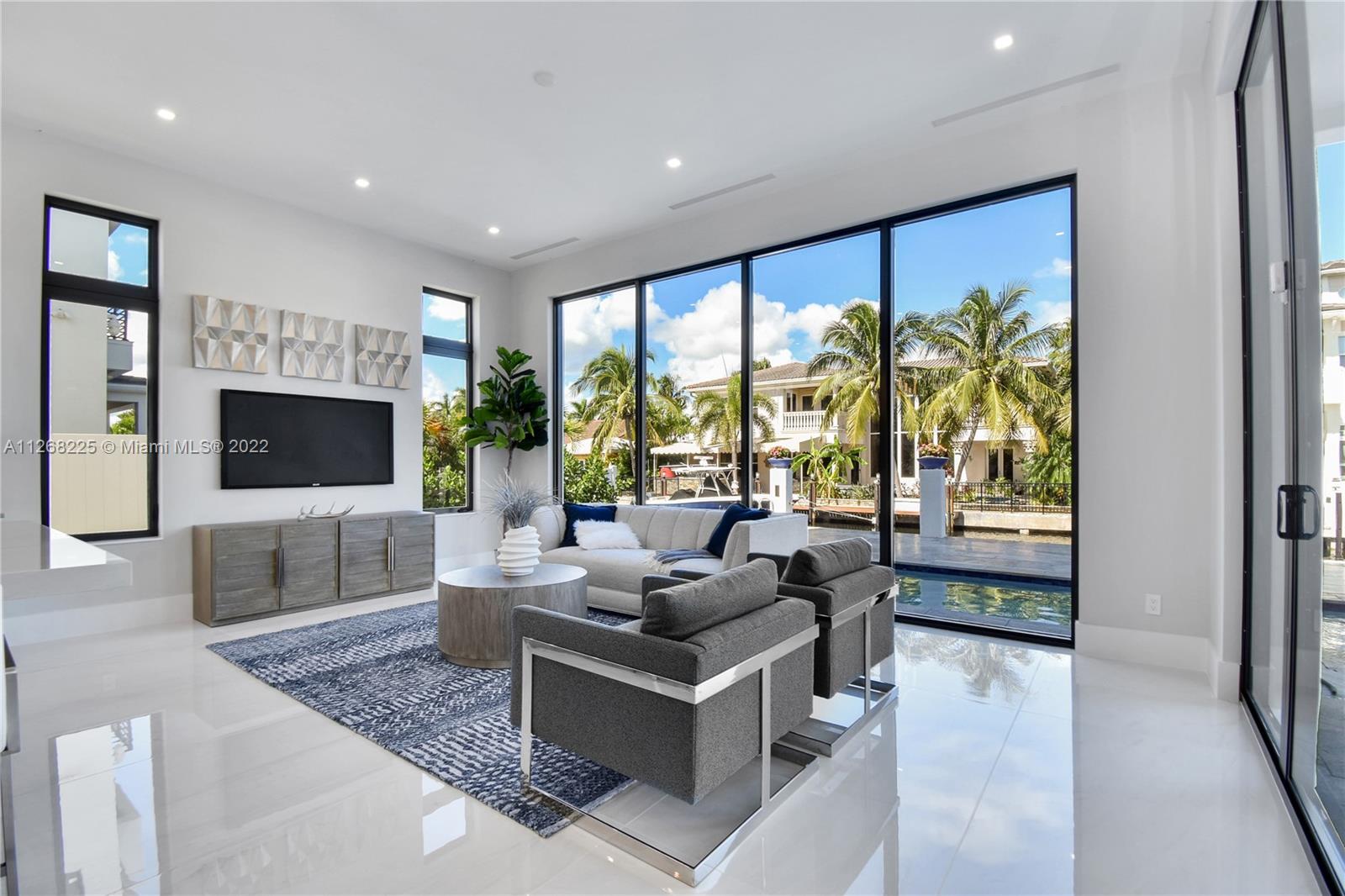805 Northeast 70th Street Boca Raton, FL 33487 - Photo 57 of 63 a living room with furniture and a flat screen tv