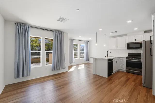 a large kitchen with a large window and stainless steel appliances