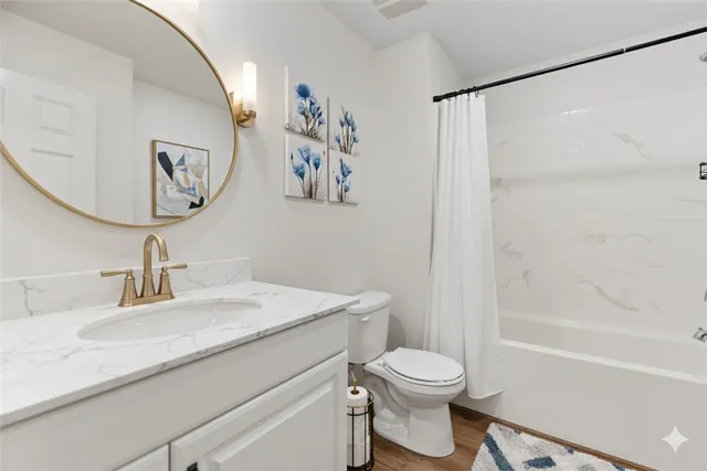 a bathroom with a granite countertop sink mirror vanity and toilet
