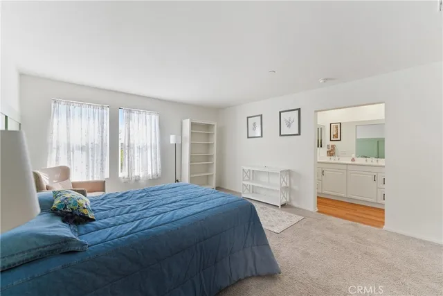 a spacious bedroom with a bed and wooden floor