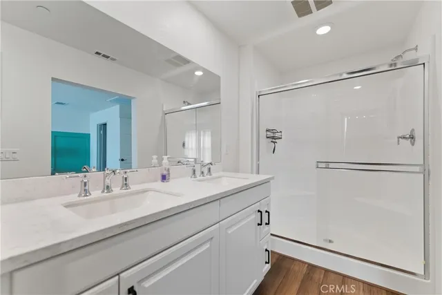 a bathroom with a shower sink mirror and shower