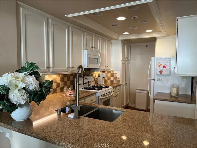 a kitchen with a sink potted plant and a window