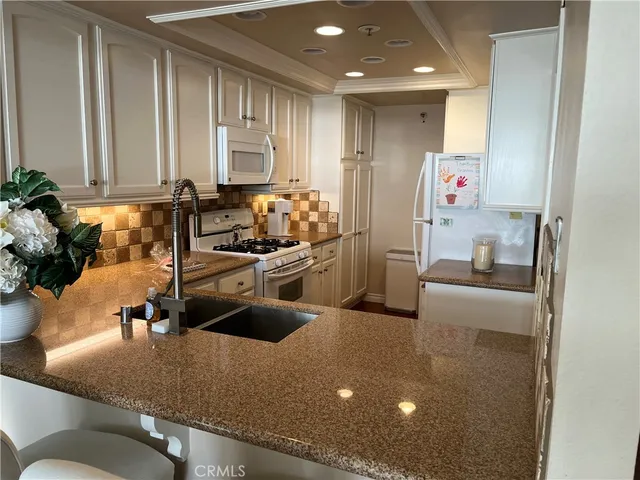 a kitchen with a sink appliances and cabinets